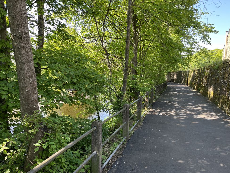 A path with trees and a water view at Bracken Cottage in Stanhope