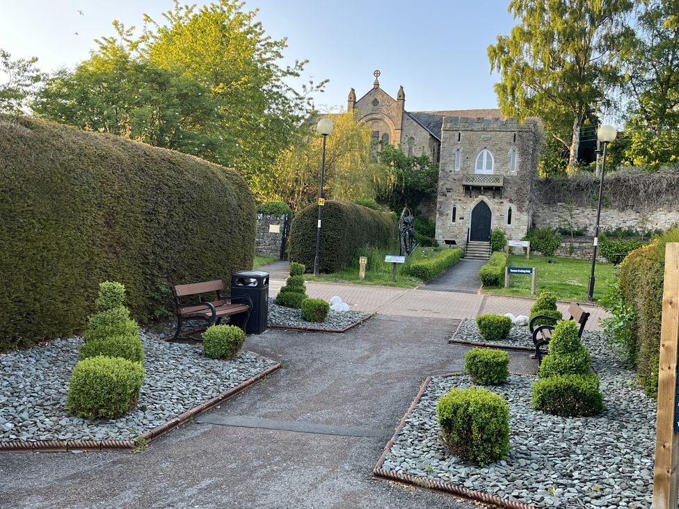 A pathway with benches and plants outside a building at Bracken Cottage in Stanhope