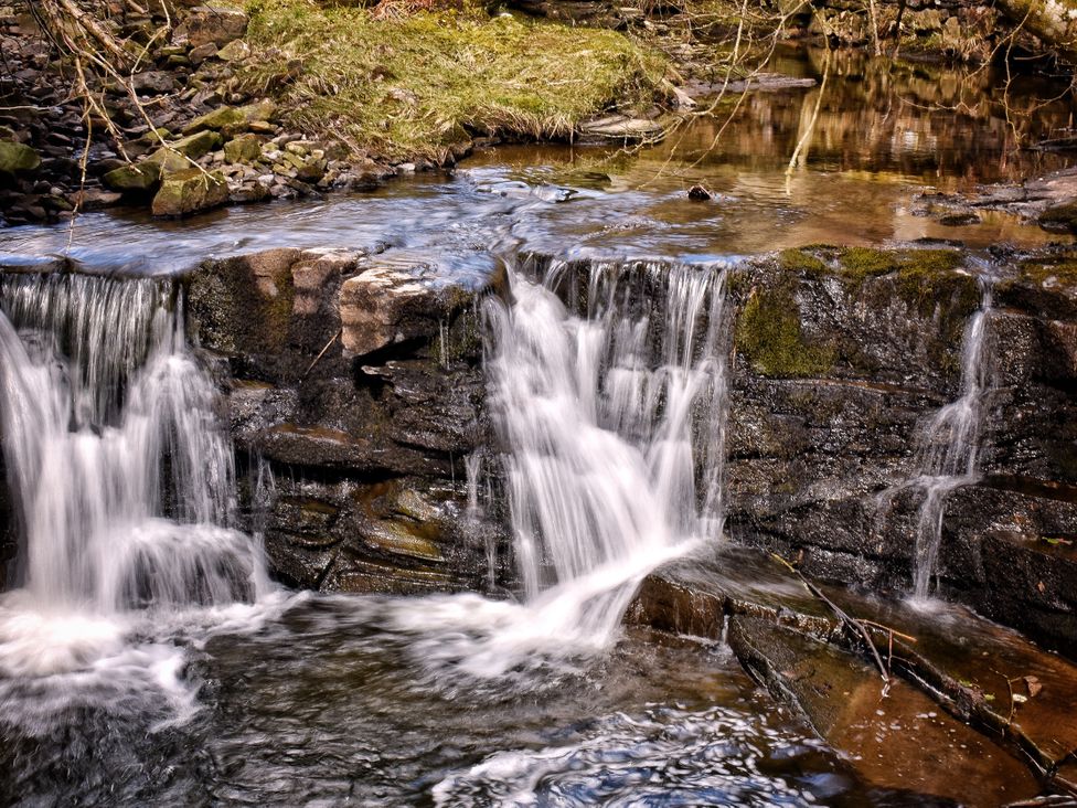 A waterfall over rocks near a stream at Bracken Cottage Stanhope