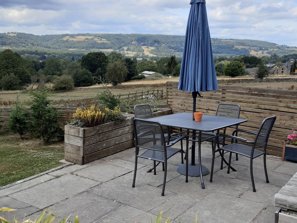 A patio with a table and chairs at Grove Farm Barn in Darley Dale