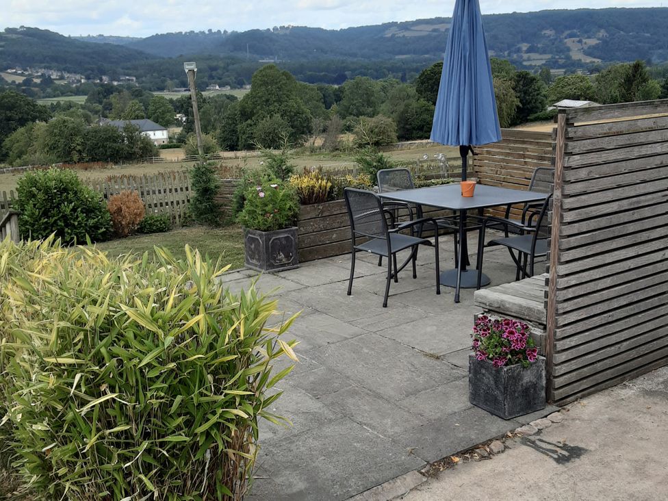 A garden with a table and chairs under an umbrella at Grove Farm Barn, Darley Dale