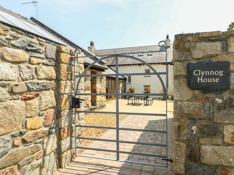 A gated entryway with a stone wall at Clynnog House in Dwyran near Newborough