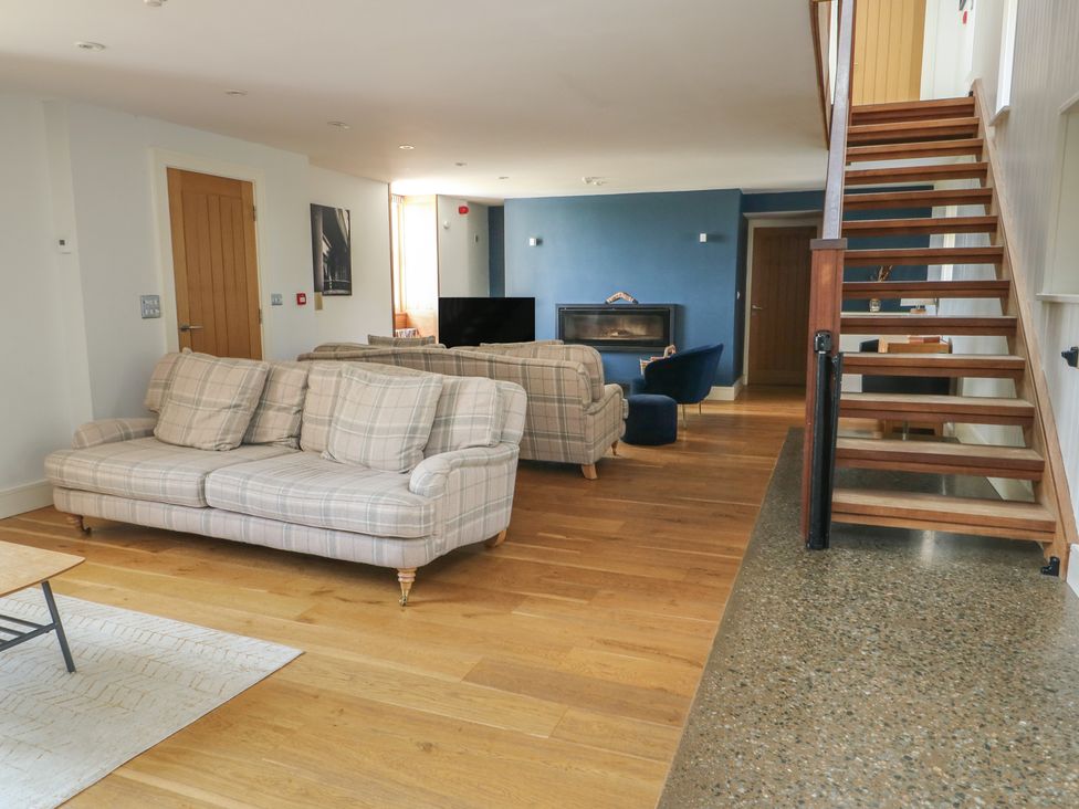 A living room with a sofa and television at Clynnog House in Dwyran near Newborough