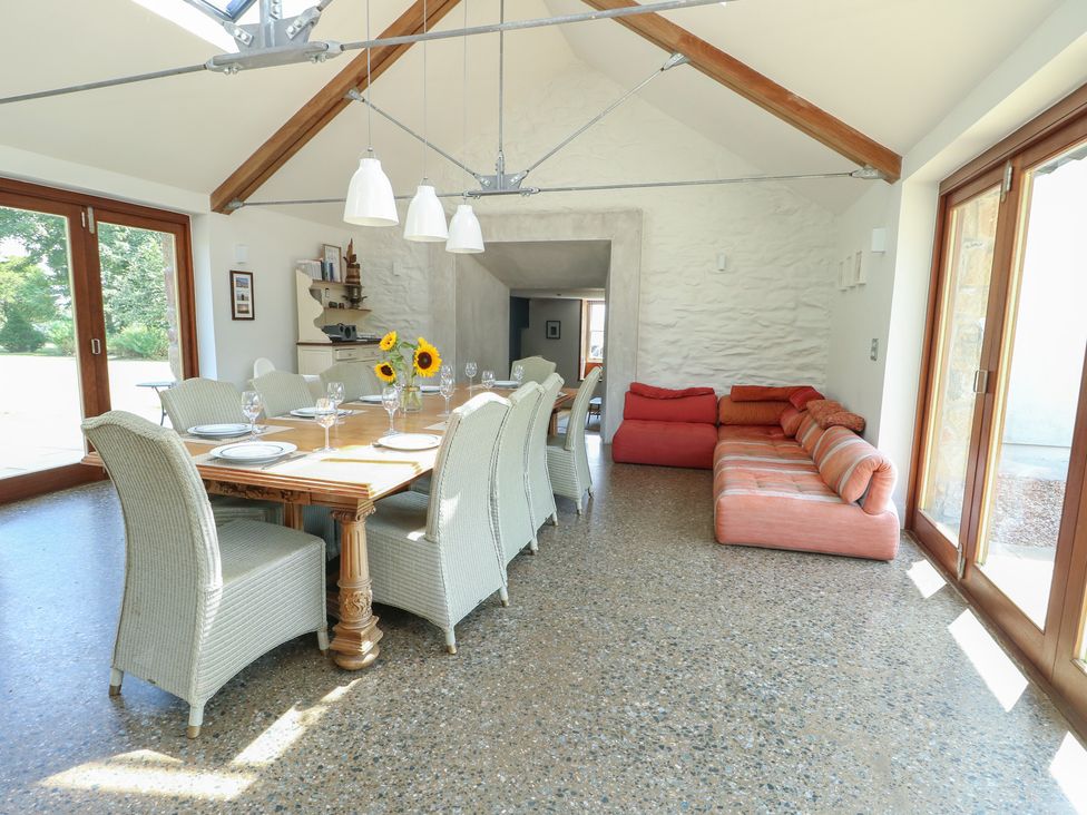 A dining room with a table and chairs at Clynnog House Dwyran near Newborough