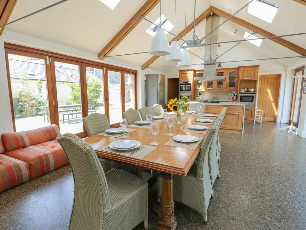 A kitchen with a dining table and chairs at Clynnog House in Dwyran near Newborough