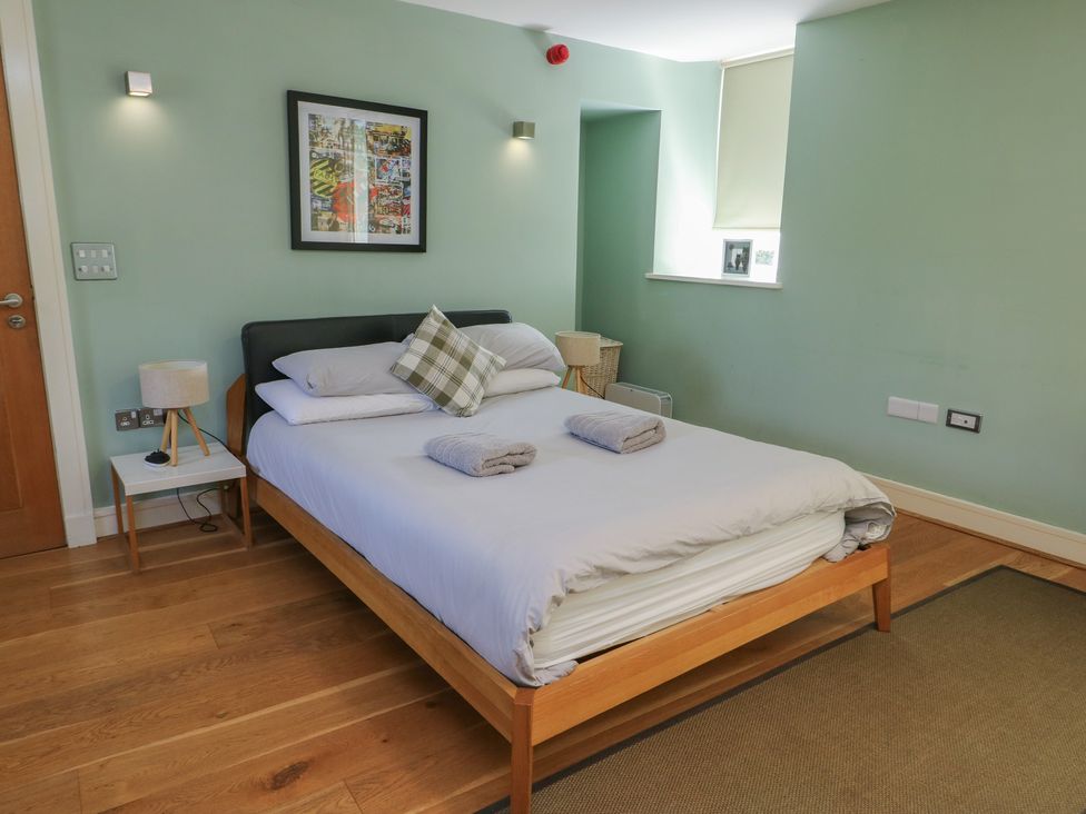 A bedroom with a bed and bedside table at Clynnog House Dwyran near Newborough
