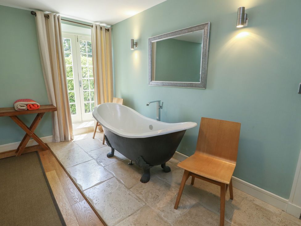 A bathroom with a bathtub and towels at Clynnog House in Dwyran near Newborough