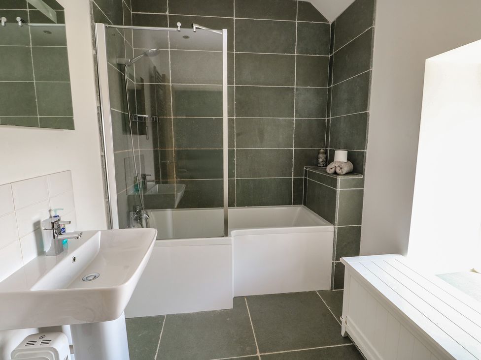 A bathroom with a bathtub and shower at Clynnog House in Dwyran near Newborough