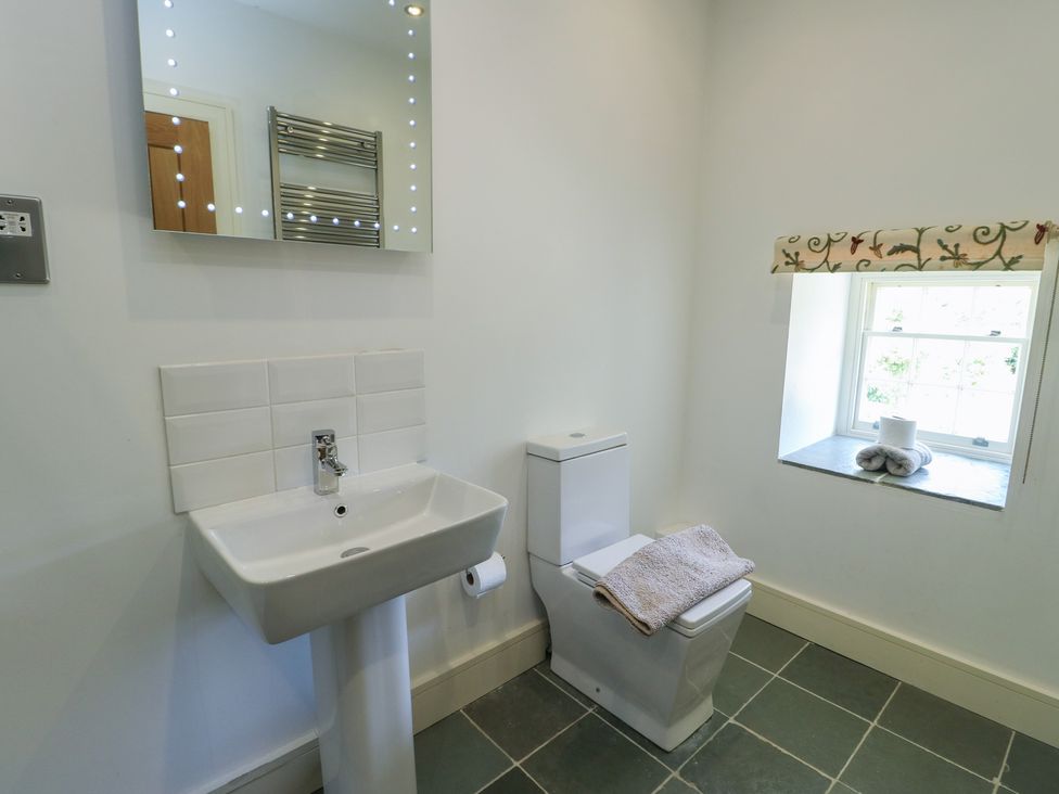 A bathroom with a wash basin and toilet at Clynnog House Dwyran near Newborough