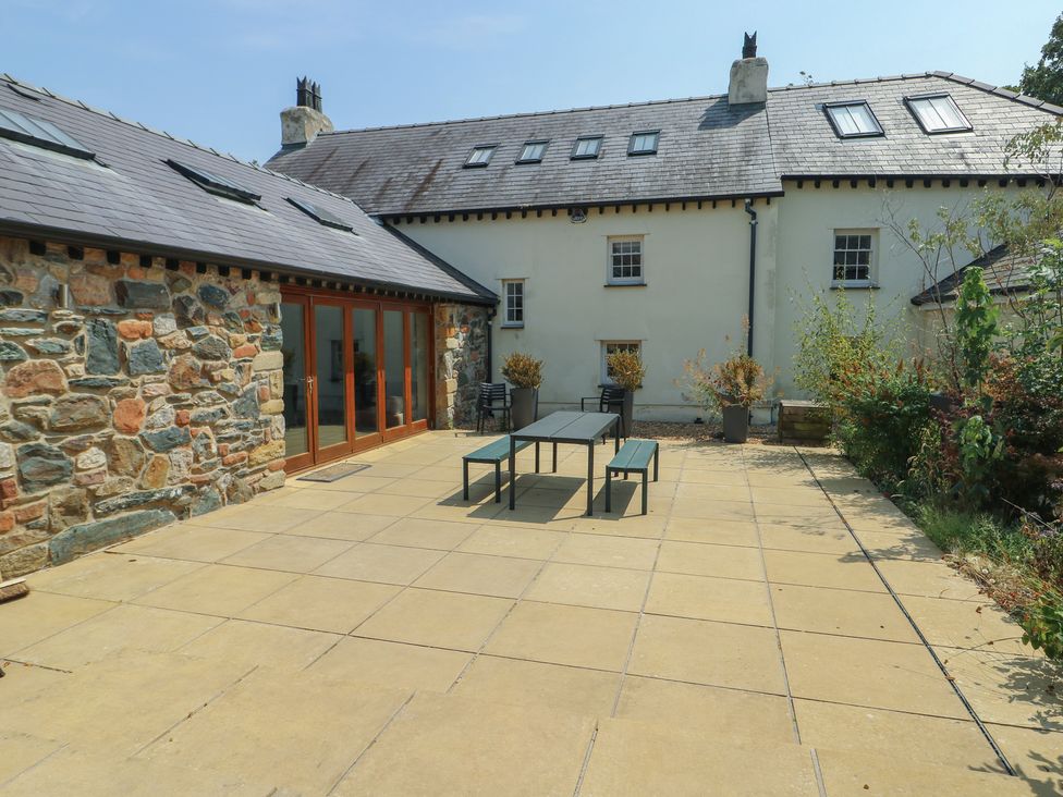 An outdoor area with a patio table and chairs at Clynnog House Dwyran near Newborough