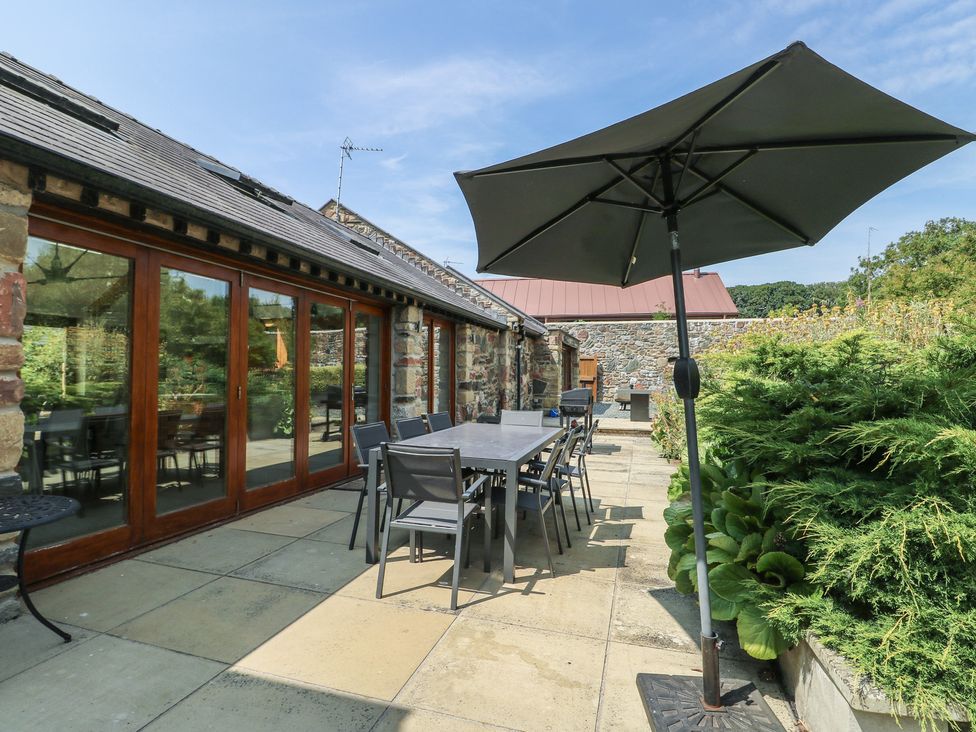 An outdoor patio area with table and chairs at Clynnog House Dwyran near Newborough