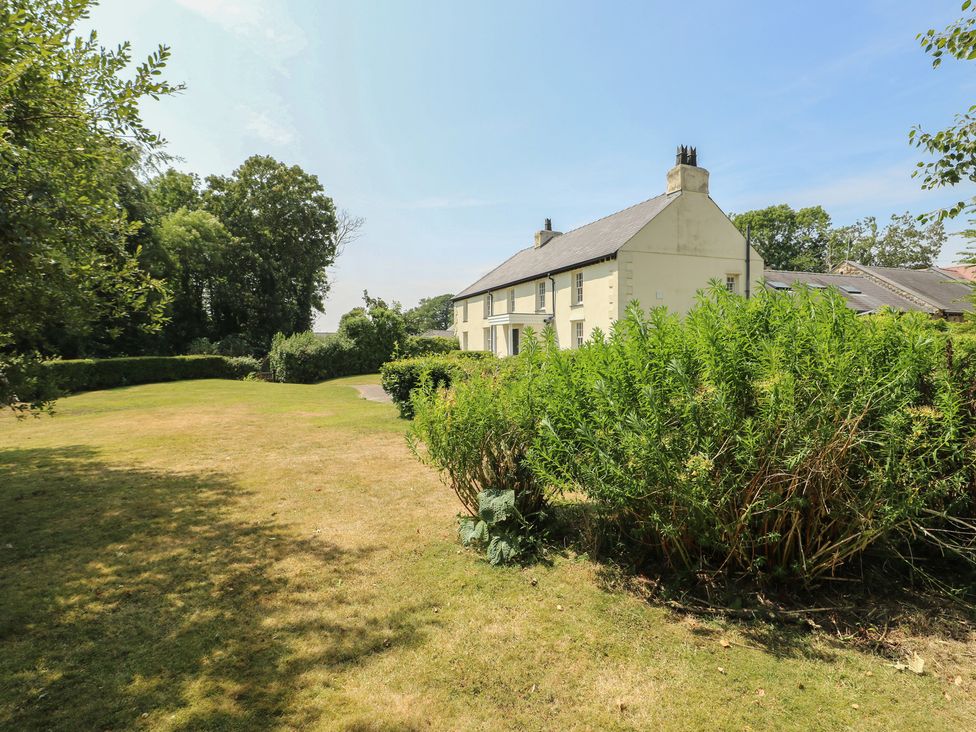 A house with a garden and trees at Clynnog House Dwyran near Newborough