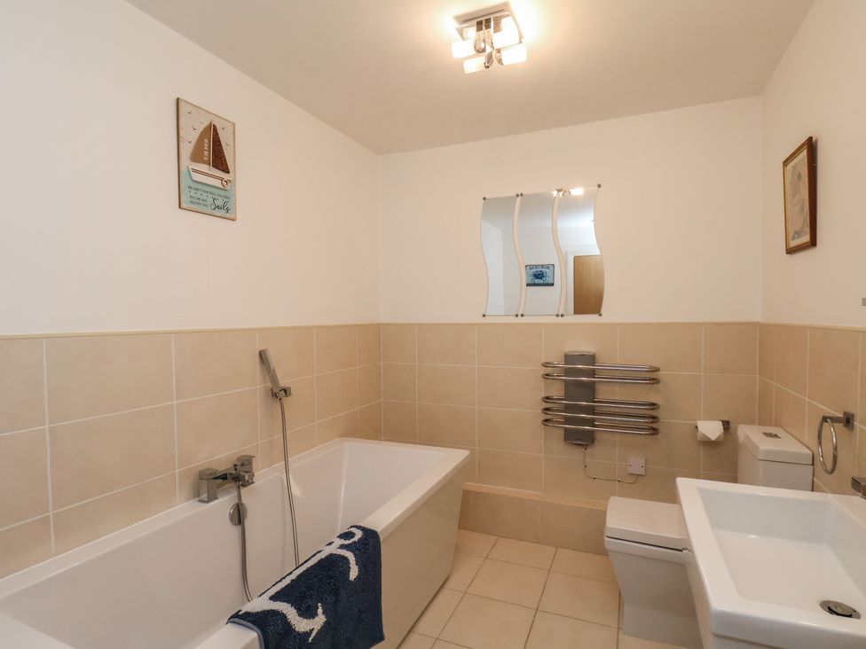 A bathroom with a bathtub, shower and toilet at Sail Away, 17 Union Mill, Whitby