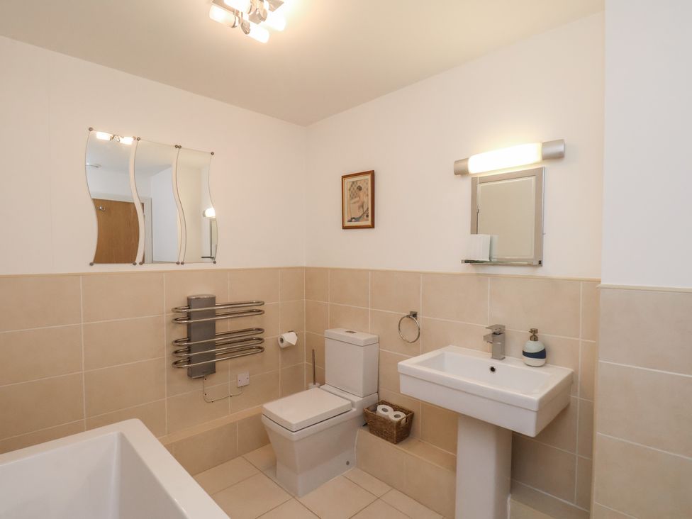A bathroom with a sink, toilet, and bath at Sail Away, 17 Union Mill in Whitby