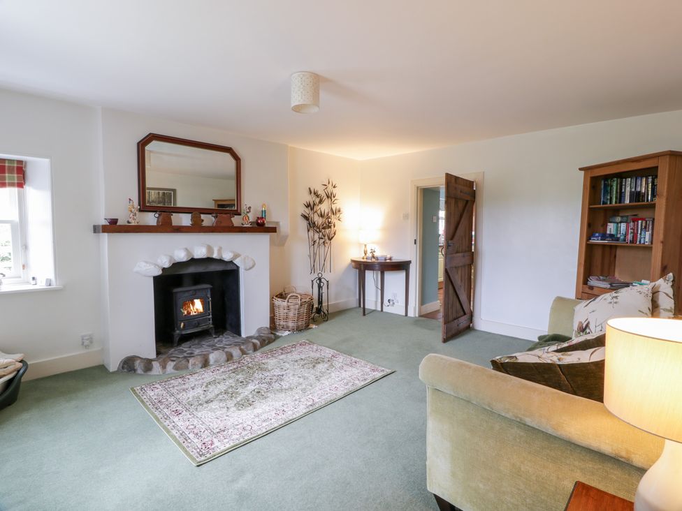 A living room with a fireplace and bookshelf at Strathannan Moffat