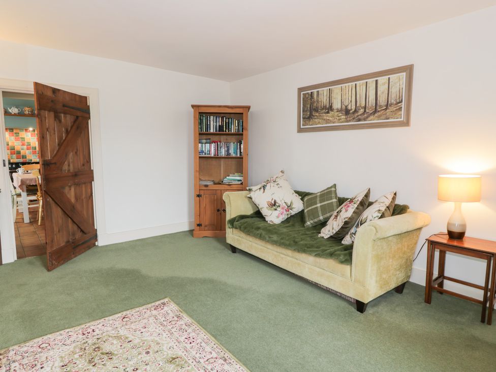 A living room with a sofa and bookshelf at Strathannan in Moffat