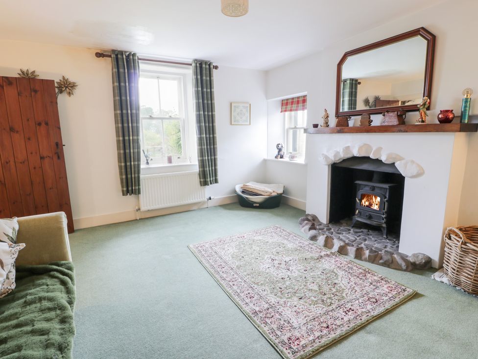 A living room with a fireplace and sofa at Strathannan in Moffat