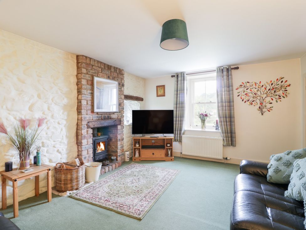 A living room with a fireplace and television at Strathannan in Moffat