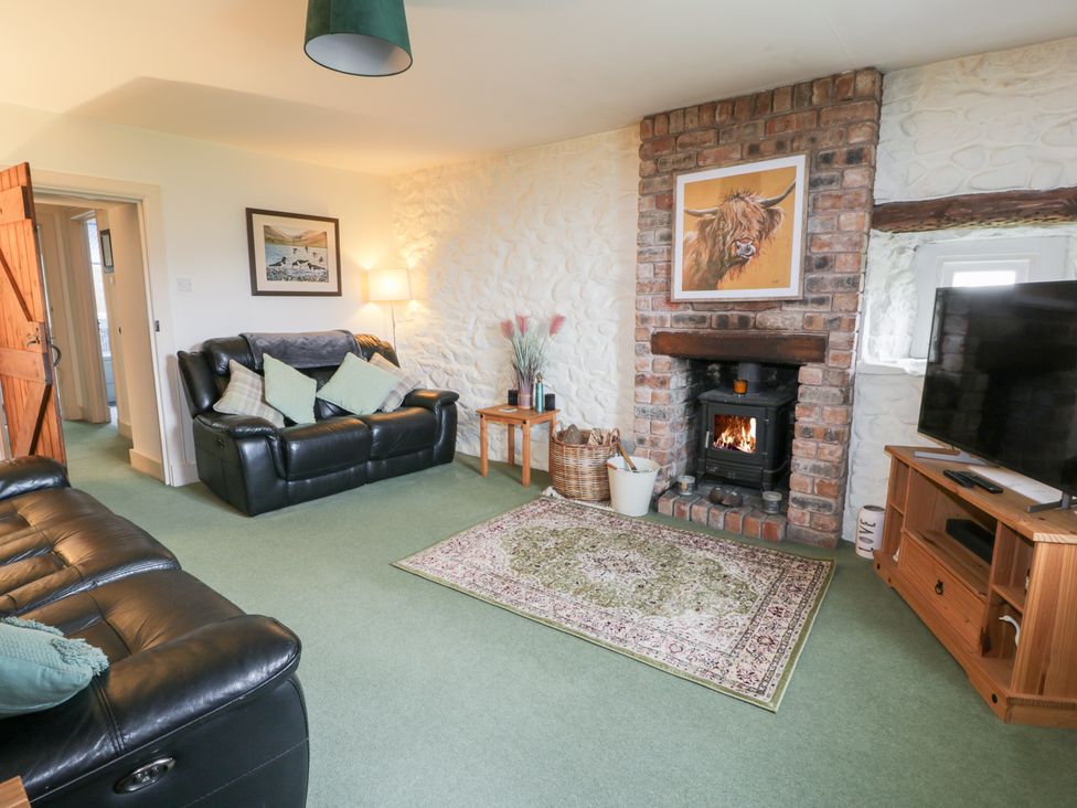 A living room with a fireplace and sofa at Strathannan in Moffat