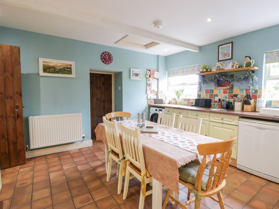 A kitchen with dining table and cabinets at Strathannan in Moffat