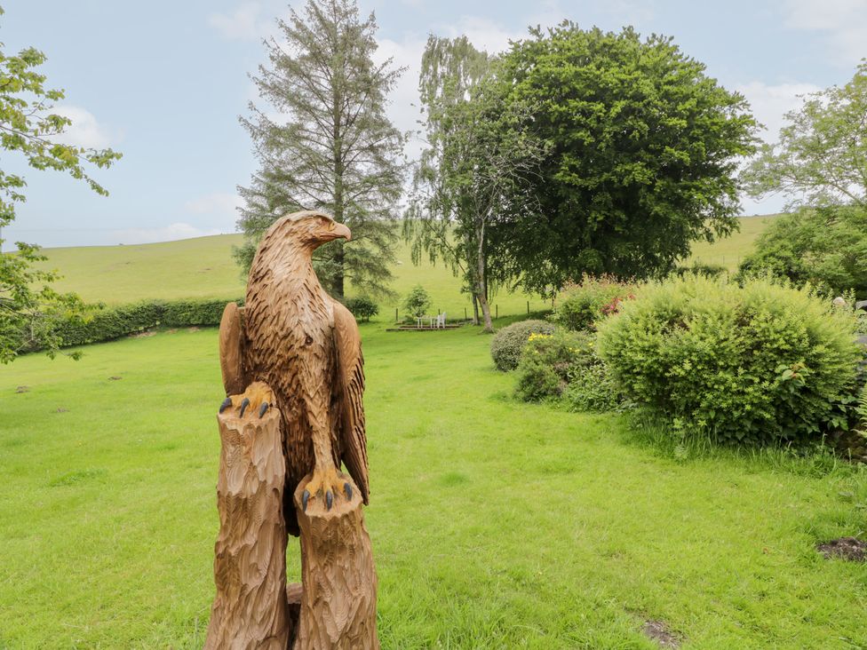 A wooden eagle sculpture in a garden at Strathannan in Moffat