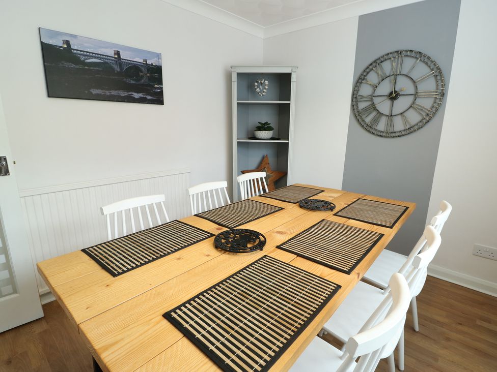 A dining room with a wooden table and chairs at Glasfryn in Holyhead