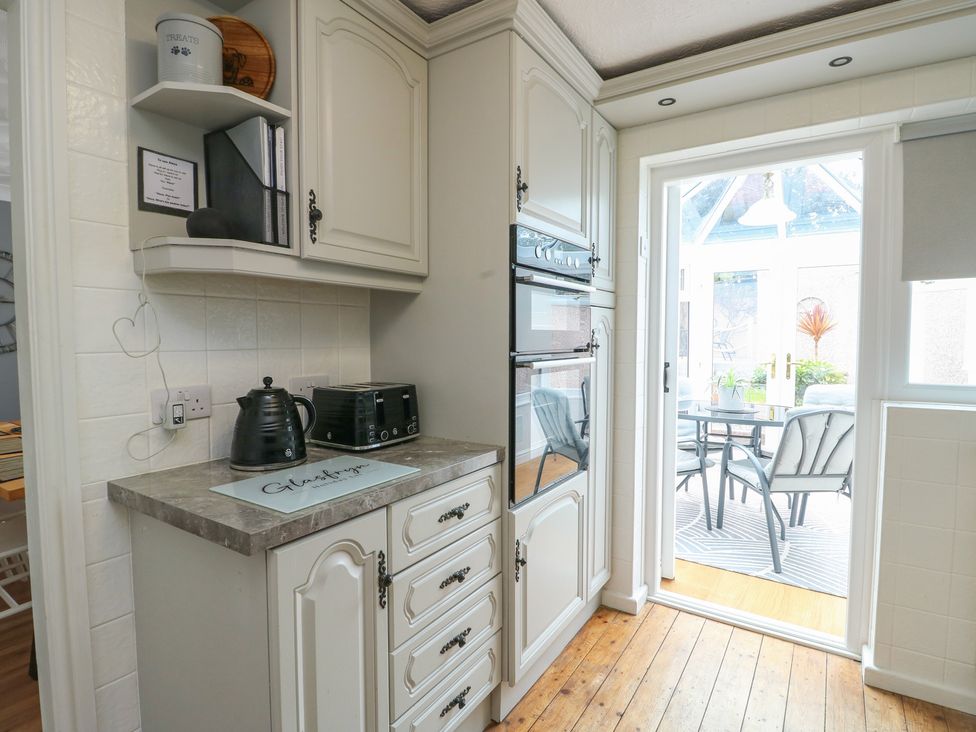 A kitchen with cabinets and appliances at Glasfryn in Holyhead