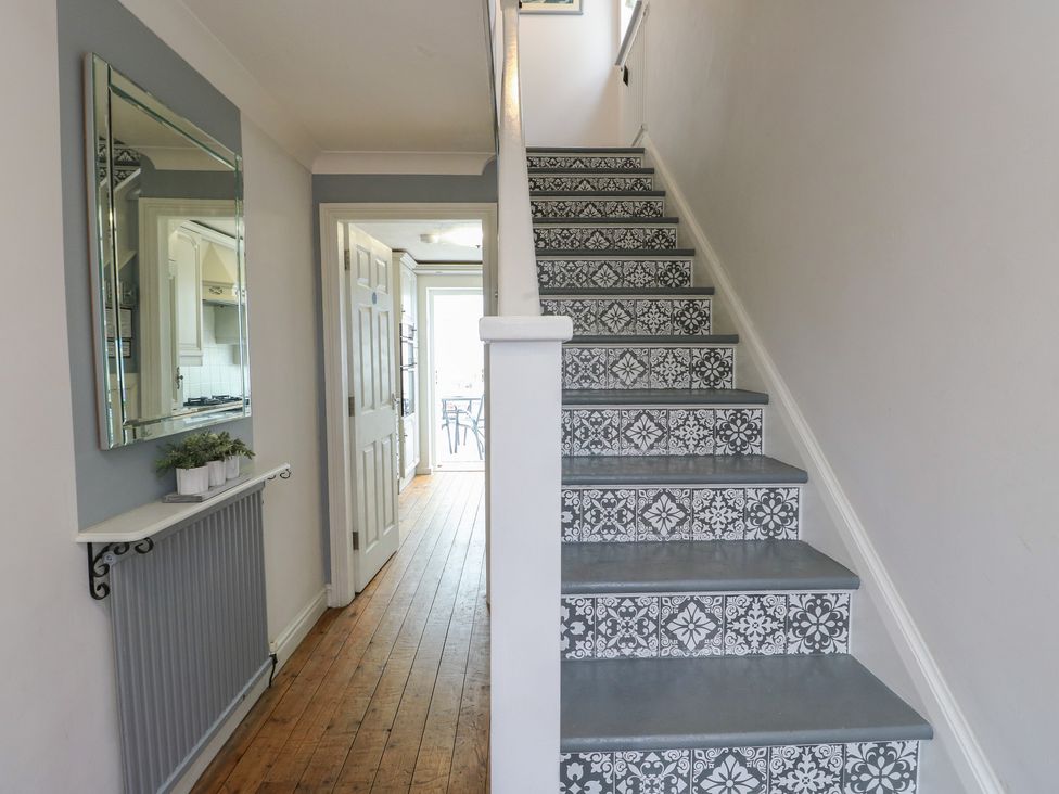 A hallway with stairs and a mirror at Glasfryn in Holyhead