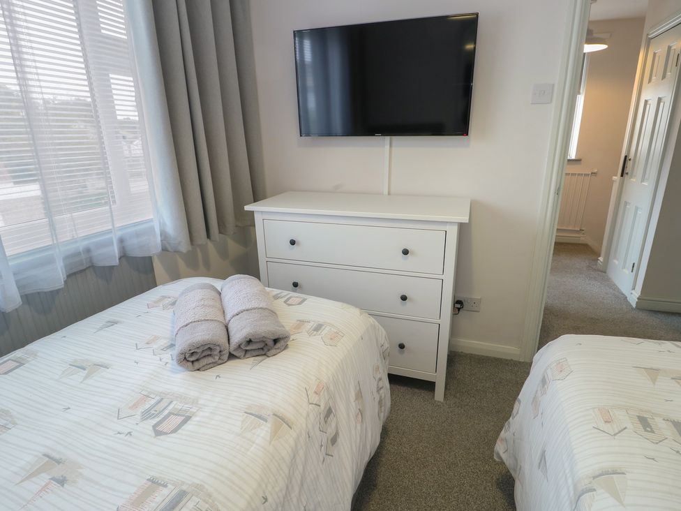 A bedroom with two beds and a television at Glasfryn Holyhead