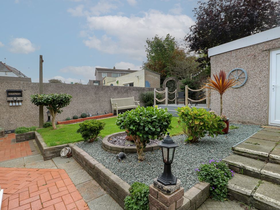 A garden with plants and a bench at Glasfryn in Holyhead