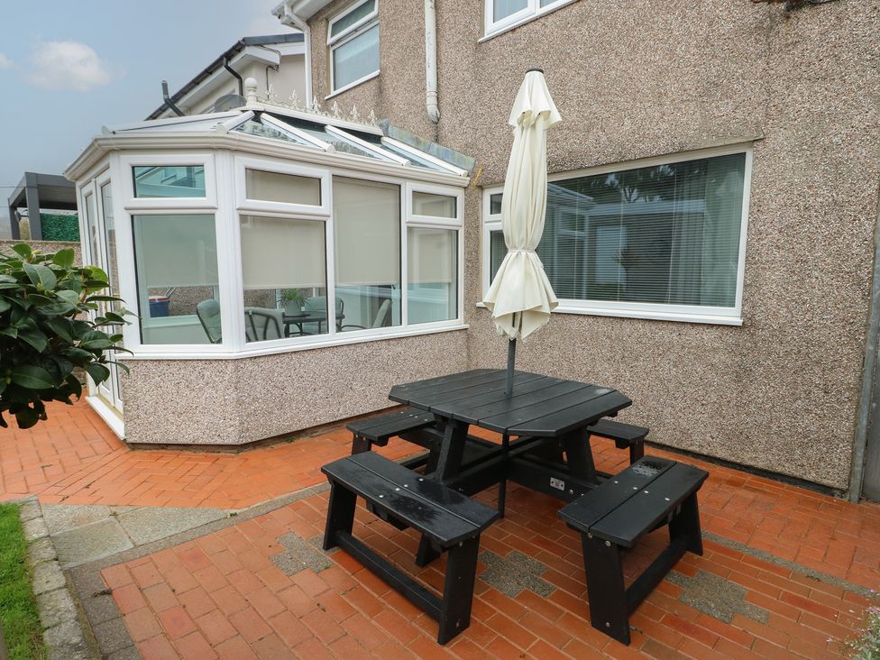 A garden area with a table and benches at Glasfryn in Holyhead