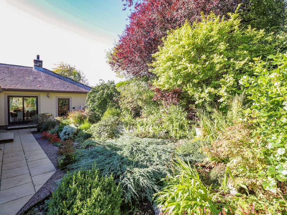 A garden with various plants and shrubs next to a house in Edencroft Greystoke