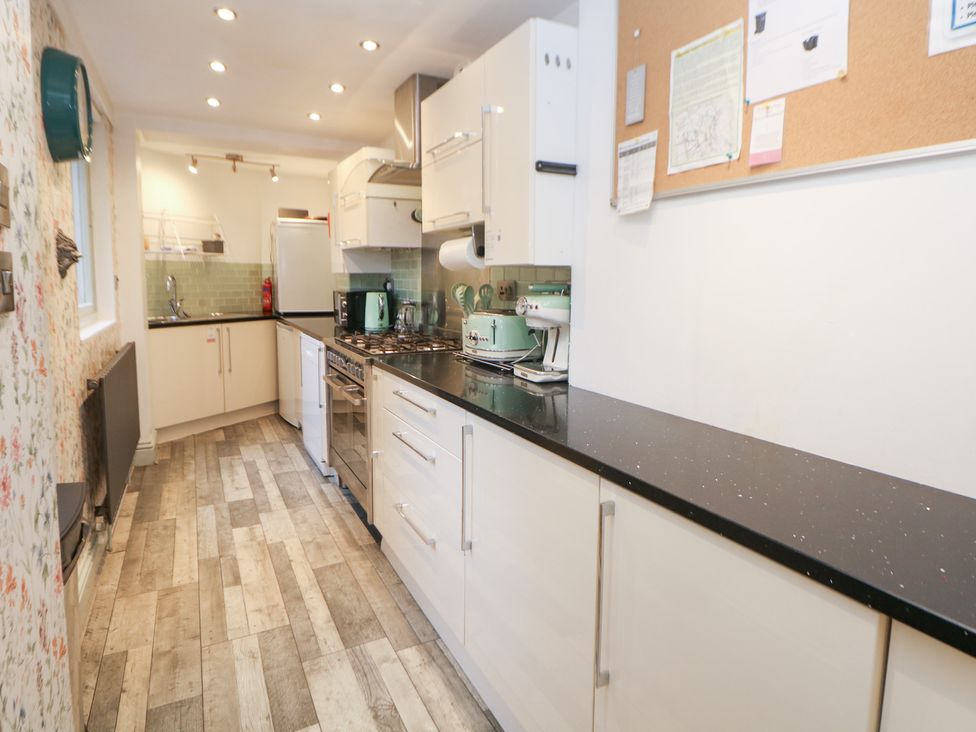 A kitchen with a cooker, fridge, and sink at Kirkham House Matlock Bath