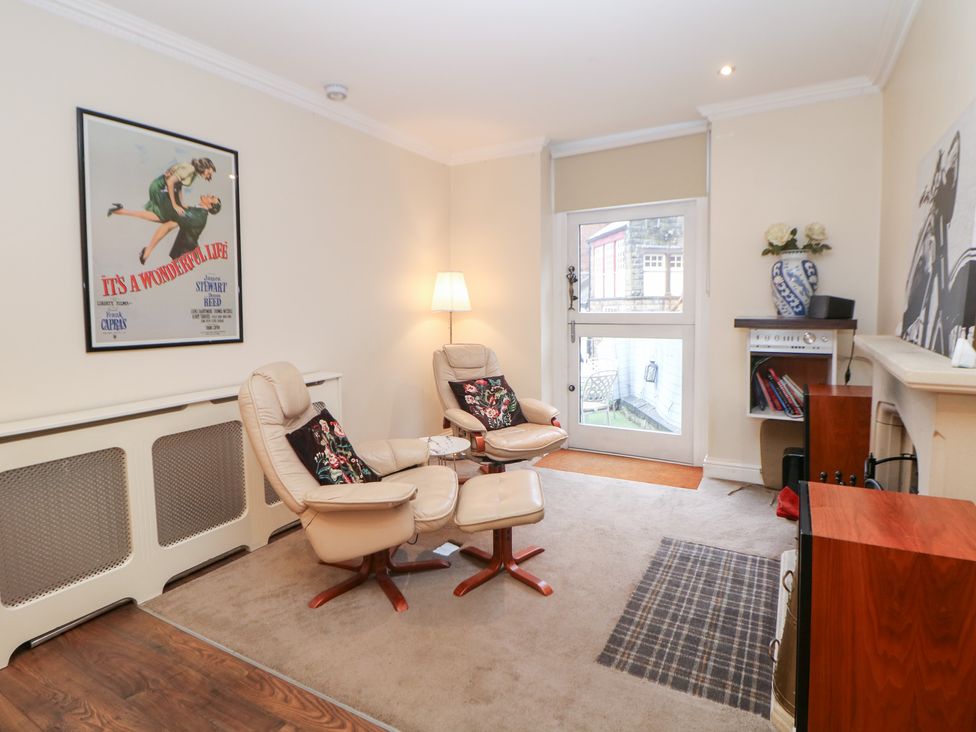 A living room with armchairs and a poster at Kirkham House in Matlock Bath