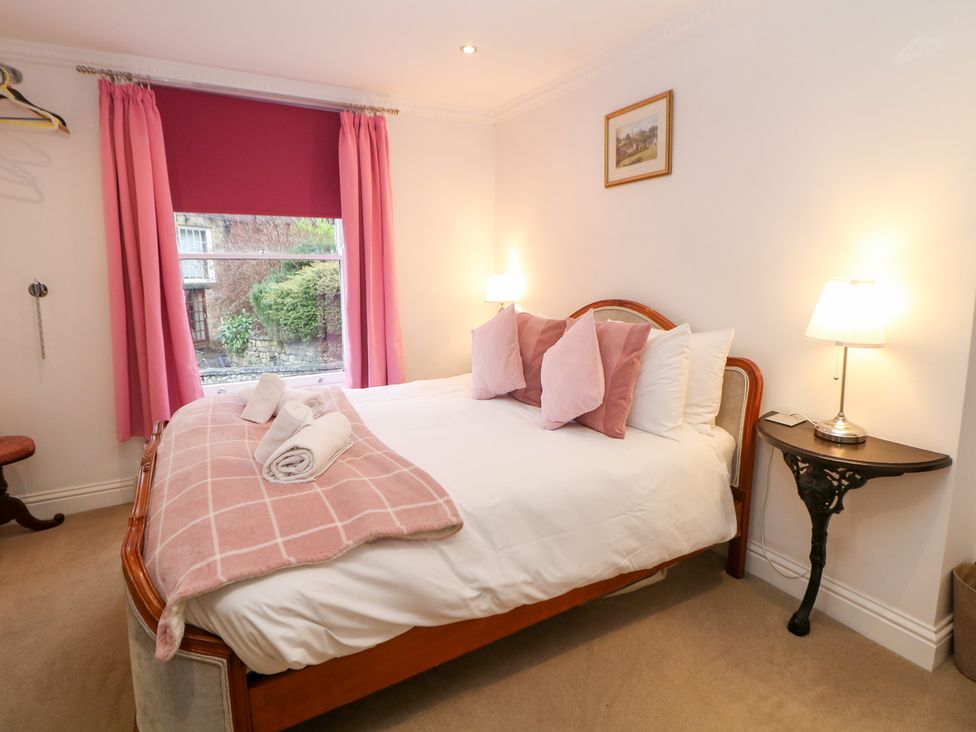 A bedroom with a bed and lamp at Kirkham House Matlock Bath