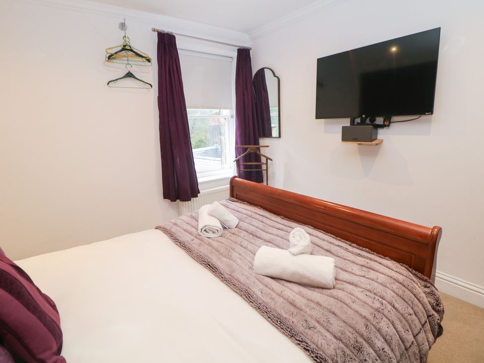 A bedroom with a bed and television at Kirkham House in Matlock Bath