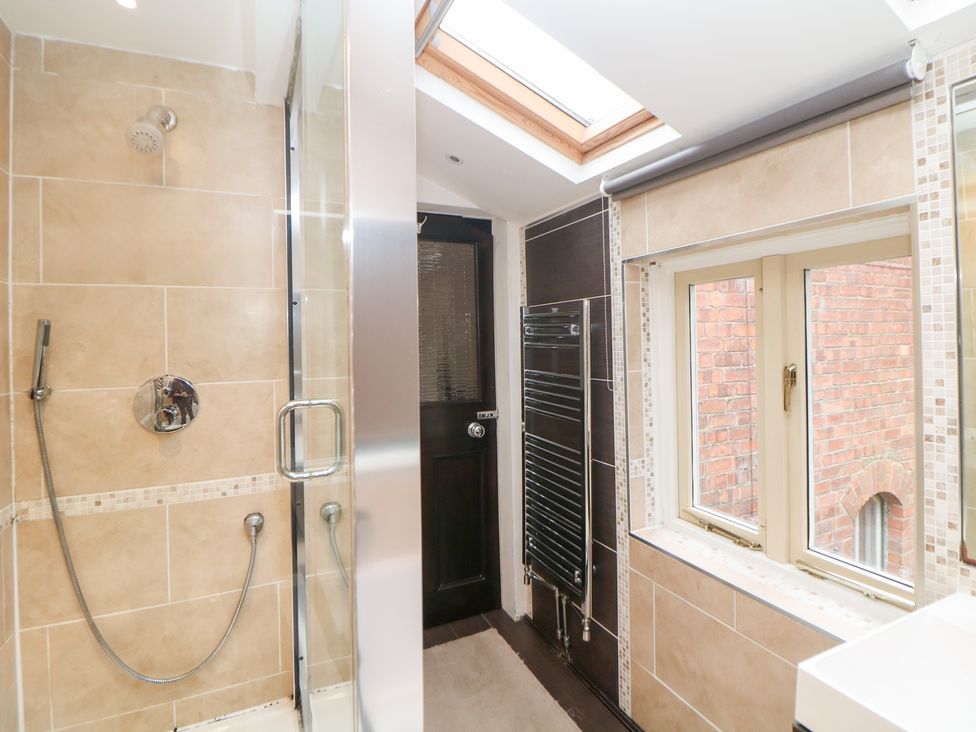 A bathroom with a shower and a window at Kirkham House in Matlock Bath