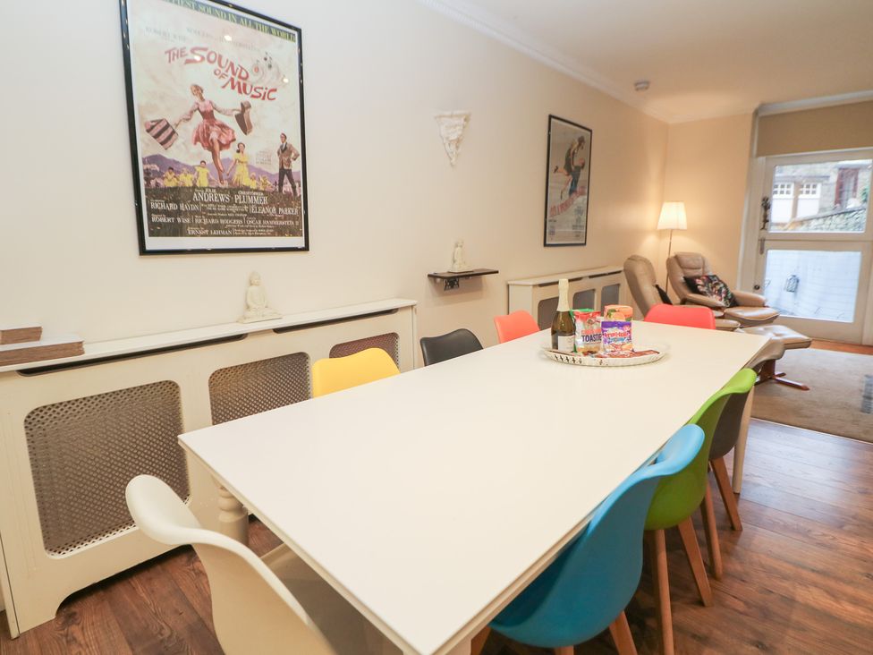 A dining room with a white table and colorful chairs at Kirkham House in Matlock Bath