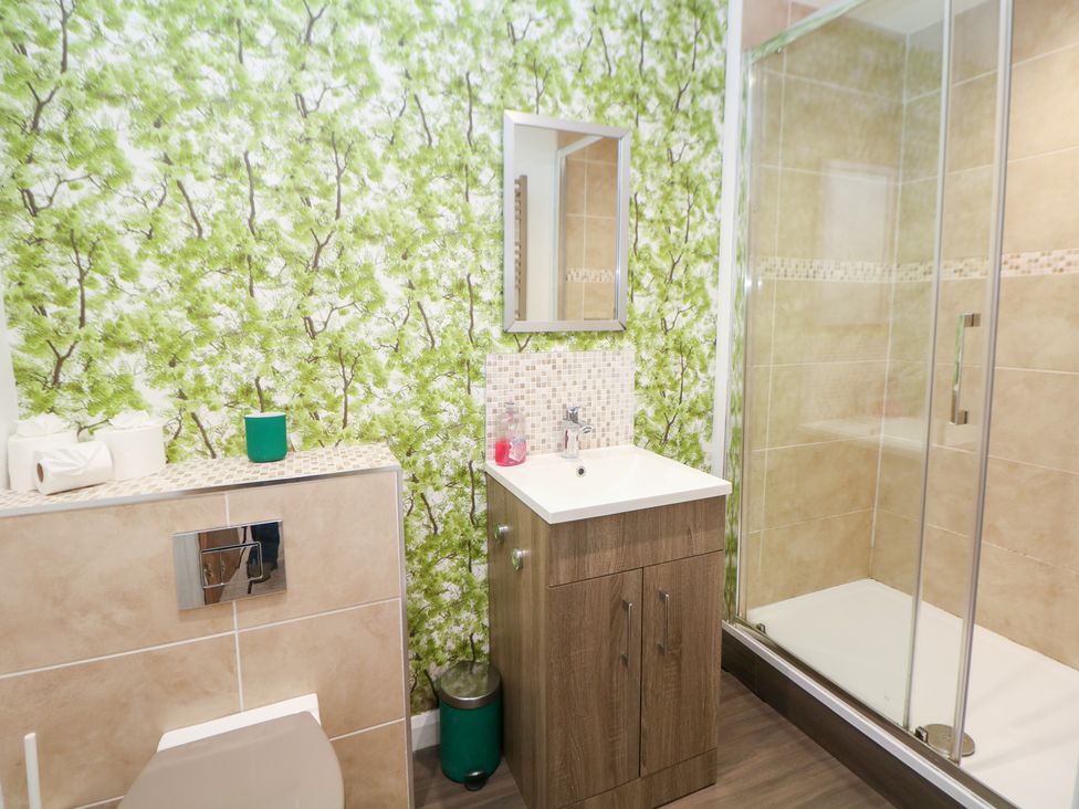A bathroom with a shower and sink at Kirkham House in Matlock Bath