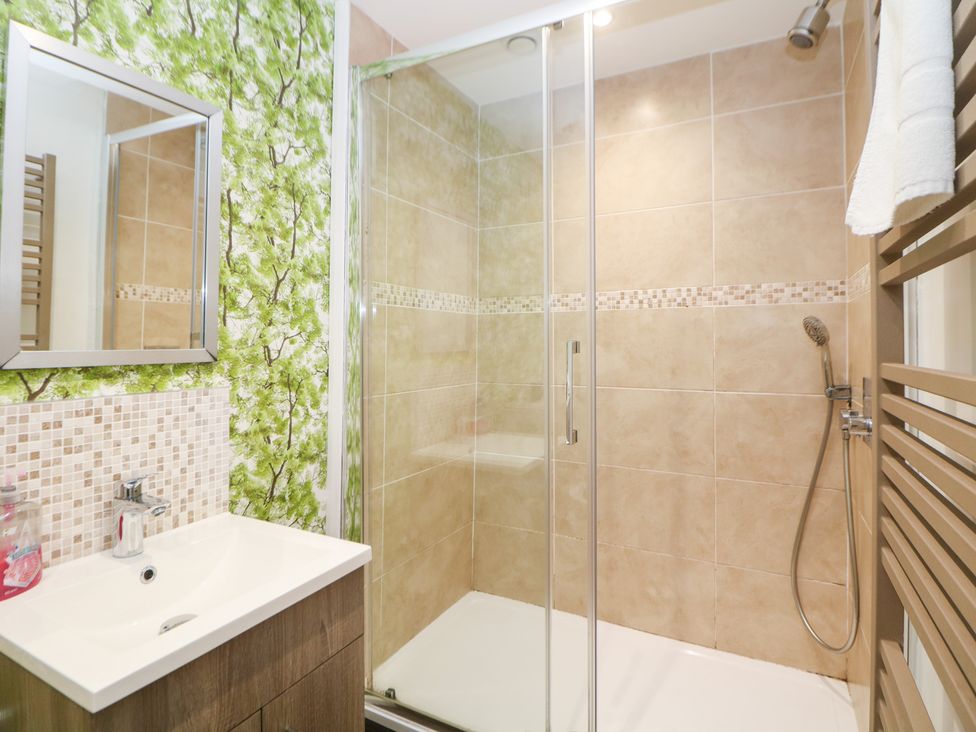 A bathroom with a shower and vanity at Kirkham House in Matlock Bath