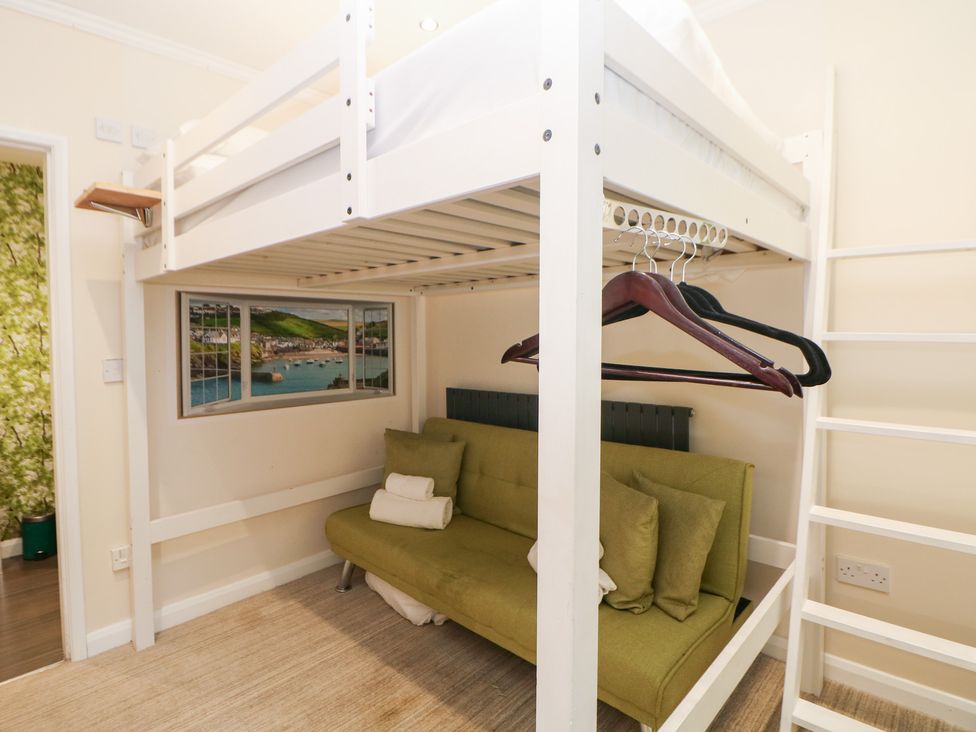 A bedroom with a bunk bed and a green sofa at Kirkham House in Matlock Bath