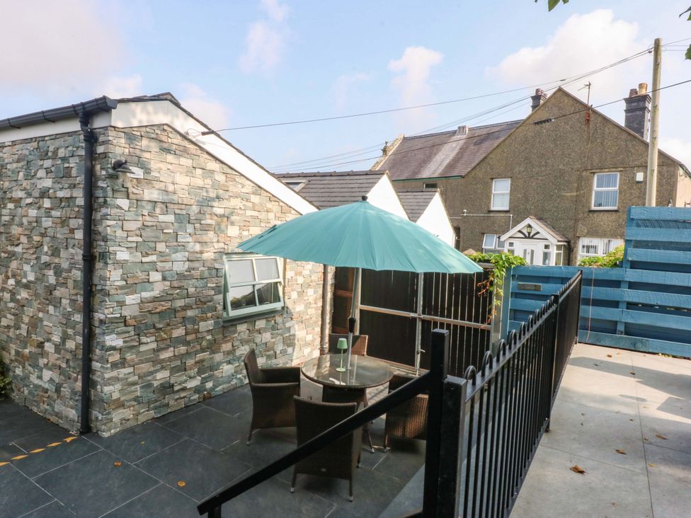 An outdoor patio with a table and chairs at Cosy Cottage in Llandegfan near Menai Bridge