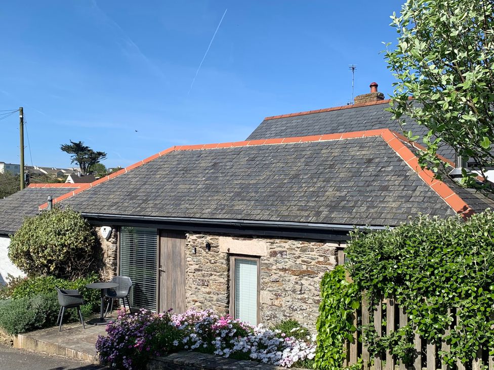 A house with flowers and chairs outside at Lavender Barn in Crantock