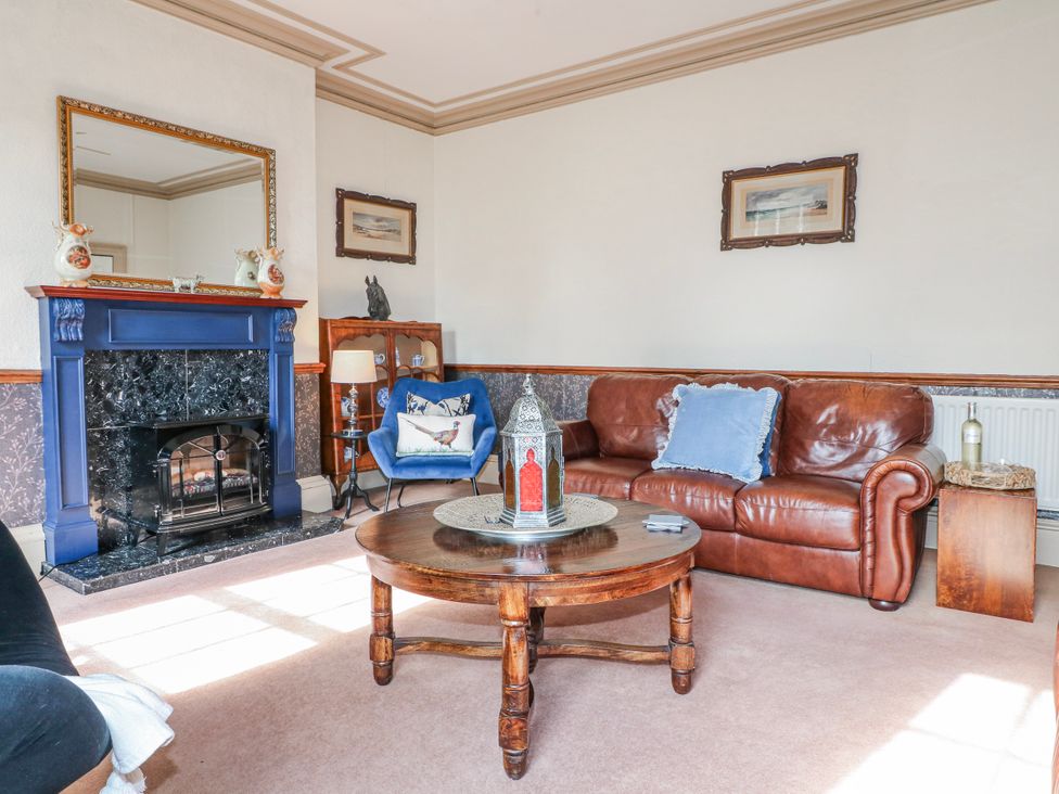 A living room with a fireplace and a sofa at Ley Fields Farm Cheadle