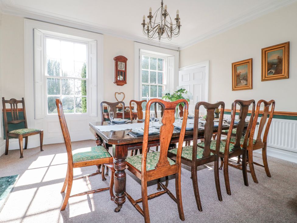 A dining room with a wooden table and chairs at Ley Fields Farm in Cheadle