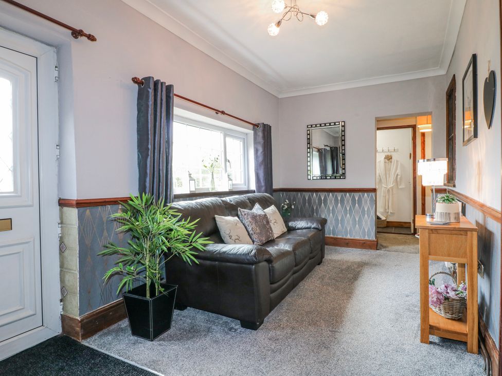 A living room with a sofa and a mirror at Ley Fields Farm in Cheadle