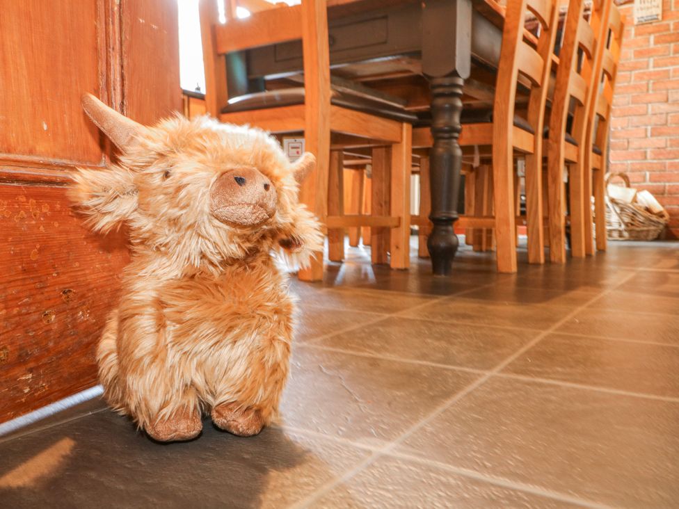 A stuffed animal near wooden furniture in a dining room at Ley Fields Farm in Cheadle