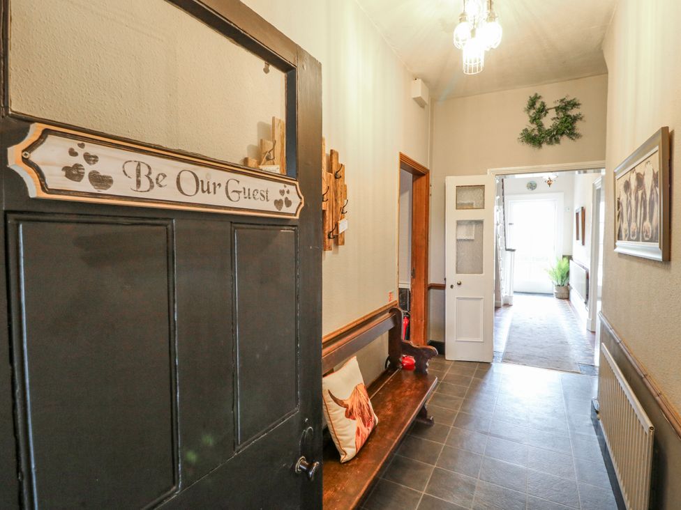 A hallway with a bench and decorative sign at Ley Fields Farm in Cheadle