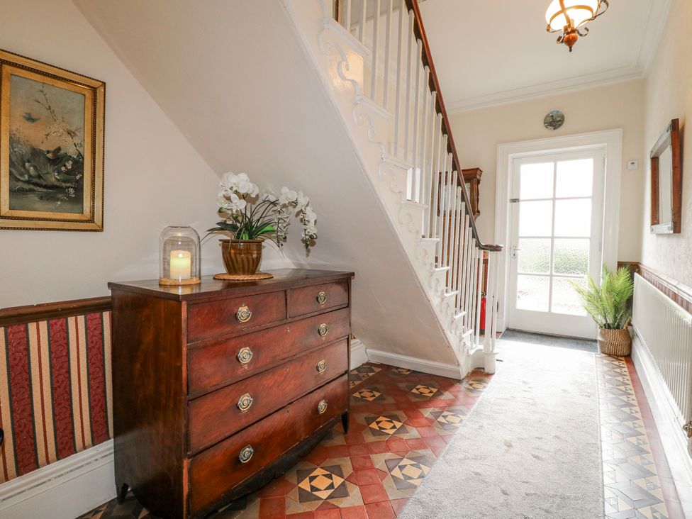 A hallway with a chest of drawers and a staircase at Ley Fields Farm in Cheadle