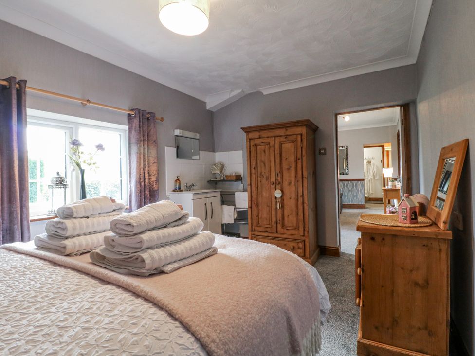 A bedroom with a bed and towels on top at Ley Fields Farm in Cheadle